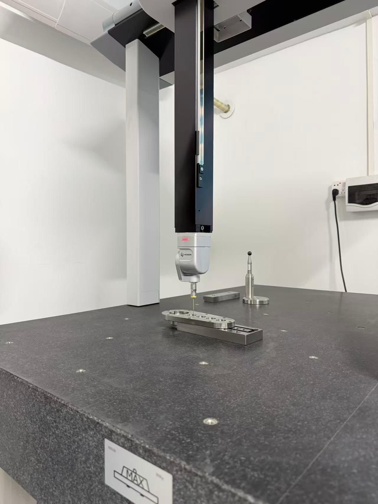 Hexagon CMM probe measuring a machined plate at Ginwate quality lab